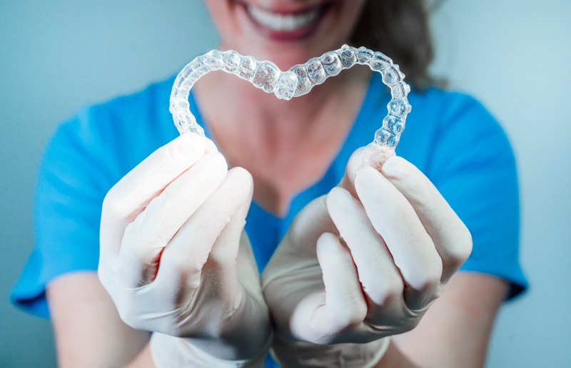 dentist making a heart with Invisalign aligners