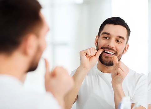 Man flossing to prevent dental emergencies in Sunnyside